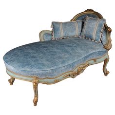 an old fashioned chaise lounge with blue cushions and gold trimmings on it