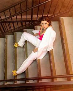 a woman in white is sitting on some stairs