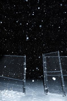 two metal gates in the snow at night