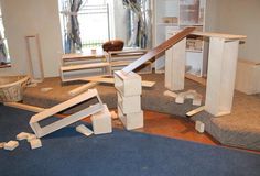 a pile of unfinished furniture sitting on top of a blue rug in a living room