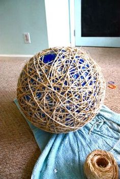 a ball of yarn sitting on top of a blue towel next to a spool of twine