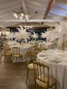 a room filled with tables and chairs covered in white tablecloths