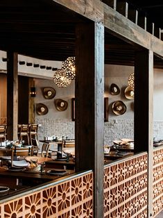 the interior of a restaurant with wooden tables and chairs, plates and utensils