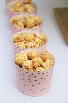 four pink polka dot paper cups filled with popcorn