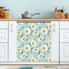 a kitchen with white cabinets and blue wallpaper has a flower pattern on the door