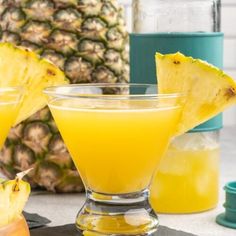 two glasses filled with pineapple punch on top of a table