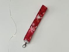 🔑 floral keychain wristlet is perfect when you are on the go. Keychain Wristlet is a perfect small gift for anyone (friends, coworkers, teachers, and etc.). ️DETAILS: - 6 inches by 1 inch -cotton fabric, batting, claw clasp -lighting may vary due to lighting  📦SHIPPING DETAILS: -key for wristlet will be shipped out the following day you order it -pinecone lanyard will be package safely and will receive some stickers -spend $35 and get free shipping -NO RETURNS OR EXCHANGES 🏷️ Get 20% off your first order when you sign up: https://mailchi.mp/d91a8b7d92af/caitlynmcr 🔑IF YOU LIKE THIS KEY FOB YOU MAY LIKE: https://mycreativereading.etsy.com?section_id=47236397 📱Social media for behind the senses and to keep up to date: INSTAGRAM: https://www.instagram.com/mycreativereading?igsh=MWd0aGR4Y Red Rectangular Wristlet With Wrist Strap, Red Wristlet With Wrist Strap For Daily Use, Rectangular Wristlet With Key Leash As Gift, Rectangular Wristlet With Key Clip As Gift, Adjustable Rectangular Red Wristlet, Rectangular Wristlet With Key Leash For Personal Use, Rectangular Keychain With Wrist Strap Gift, Rectangular Keychain With Wrist Strap, Floral Keychain