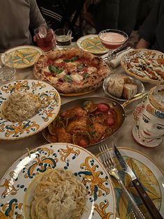 a table topped with lots of plates and bowls filled with different types of food on top of it