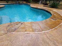 an outdoor swimming pool with stone steps leading up to it