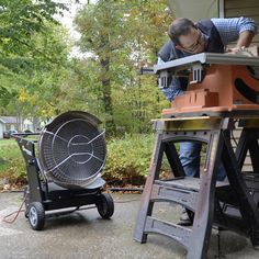 a man working on an outdoor table sawing