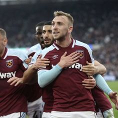 two soccer players are hugging each other in the middle of a group huddle together