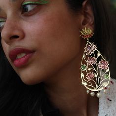 These Lotus Flower Resin Earrings are a delicate blend of elegance and artistry. Crafted to resemble the graceful lotus flower, the earrings feature a teardrop shape with intricate pink and green floral patterns set against a translucent backdrop. Gold-tone accents highlight the edges, and small pearls at the base add a touch of sophistication. These earrings are a modern take on traditional floral motifs, perfect for fashion enthusiasts and those who appreciate handcrafted jewelry.  The earrings dangle gracefully from gold-plated hooks, ensuring they are lightweight and comfortable for all-day wear. Whether you're dressing up for a special occasion or adding a unique flair to your everyday outfit. Celebrate your love for nature and bees with this charming piece of jewelry. Dimension : Len Lotus Earrings, Long Dangle Earrings, Etsy Earrings Dangle, Floral Motif, Statement Earrings, Pink And Green, Handcrafted Jewelry, Nature Inspiration, Gold Tones