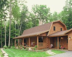 a log cabin with large front porch and wrap around deck on the side of it