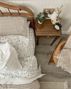 an overhead view of a bed with pillows and blankets on it, next to a night stand