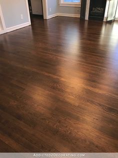 an empty living room with hard wood flooring and white trim on the door way