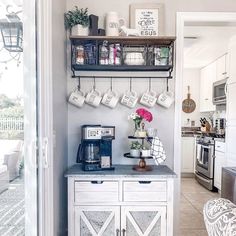 a kitchen with white cabinets and gray counter tops, open shelves on the wall above it