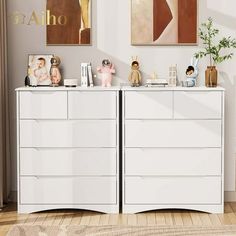 two white dressers in a room with pictures on the wall