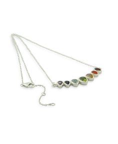 A row of inverted teardrops set with sparkling gemstones imbues this necklace with a thoroughly regal vibe. Facet cut for an extra dazzling effect, each of the gemstones corresponds to a different chakra. From left to right, the gemstones include amethyst, iolite, topaz, peridot, citrine, carnelian, and garnet. Crafted with a sterling silver setting, this pendant is 2 inches wide and 0.25 inches long. The necklace is 18 inches long and has a 2-inch chain extension. Made in India. Majestic seven Chakra Necklace, Chakra Jewelry, Crown Chakra, Plexus Products, Gemstone Colors, Gemstone Pendant, Long Necklace, Blue Topaz, Citrine