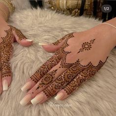 two hands with henna tattoos on them