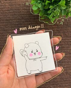 a hand holding a small card with a drawing of a bear on it's back