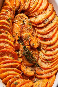 baked sweet potatoes with herbs and seasoning in a casserole dish