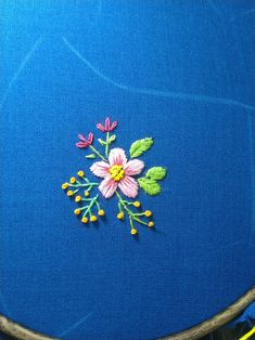 a close up of a piece of cloth with embroidery on it and flowers in the center