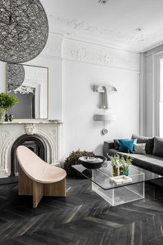 a living room filled with furniture and a fire place next to a large glass table