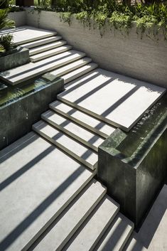 an outdoor water feature on the side of a building with steps leading up to it