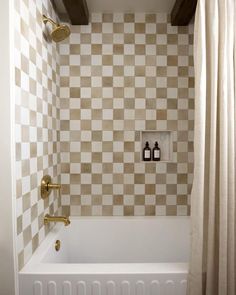 a white bath tub sitting under a window next to a shower curtain and a radiator