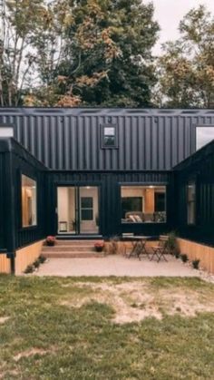 a house made out of shipping containers sitting in the grass