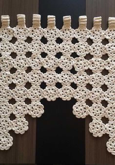 crocheted doily hanging on the side of a wooden door with black background