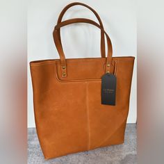 Le Donne Leather Large Slip Pocket Tote Cognac Tan Nwt Measurements Height: 14” Width: 14” Depth: ~3” Strap Drop: 9” Features: Premium Full-Grain Colombian Vaquetta Leather Handcrafted By Skilled Colombian Craftsmen Front Slip Pocket Nwt Condition. Please See Photos. Non Smoking, Pet Friendly Home *Posted On Multiple Sites* Thank You Large Capacity Tan Leather Satchel, Everyday Bags With Signature Hardware, Brown Bags With Signature Hardware For Everyday Use, Brown Travel Bag With Signature Hardware, Shoulder Bag With Signature Hardware, Chic Everyday Bags With Signature Hardware, Brown Rectangular Satchel With Signature Hardware, Brown Satchel Bag With Signature Hardware, Brown Satchel With Signature Hardware For Everyday