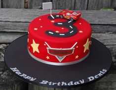 a red birthday cake with a car on the front and number 6 on the back