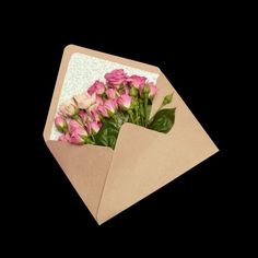 a bouquet of pink roses in an envelope