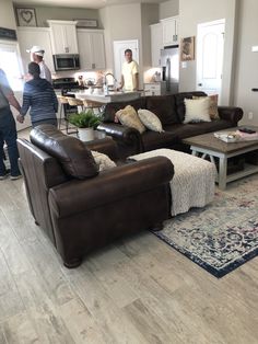 two people are standing in the kitchen and living room