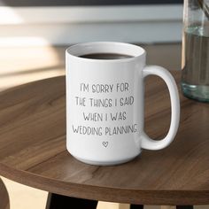 a white coffee mug sitting on top of a wooden table