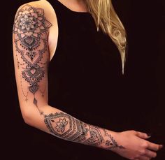 a woman's arm with an intricate tattoo design on her left arm and shoulder