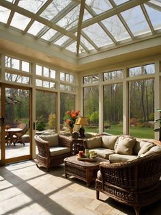 a sun room with wicker furniture and large windows on the wall, along with glass doors leading to an outside patio area