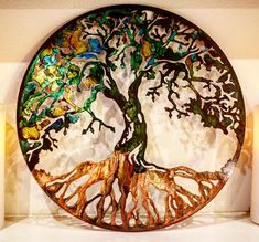 a metal plate with a tree of life on it and candles in front of it