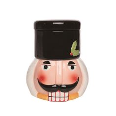 a ceramic nutcracker with a top hat and holly on it's head