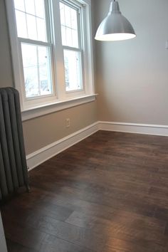 an empty room with wood floors and a radiator on the wall next to it