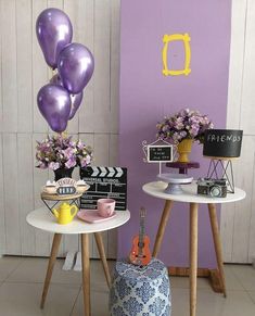 two small tables with purple balloons on them