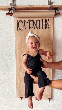 a man holding a baby in front of a sign that says, momths