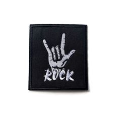 a black and white patch with the word rock written on it's left hand