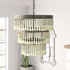 a chandelier hanging from the ceiling in a room with a potted plant