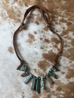 Adjustable genuine leather with faux turquoise shards and faux Navajo pearl beads. Adjustable Beaded Rustic Turquoise Necklace, Adjustable Brown Turquoise Bohemian Necklace, Adjustable Hand-strung Turquoise Necklace For Festivals, Handmade Rustic Adjustable Turquoise Necklace, Adjustable Southwestern Turquoise Necklace For Festivals, Southwestern Adjustable Turquoise Necklace For Festivals, Adjustable Turquoise Necklace With Natural Stones For Festival, Rustic Beaded Turquoise Necklace, Southwestern Turquoise Leather Jewelry