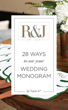 the wedding monogram is displayed on top of a table with white flowers and greenery