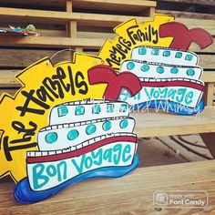 two wooden signs that are sitting on some wood planks, one has a boat and the other says bon voyage