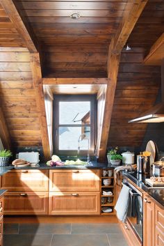 a kitchen with wood paneling and tile flooring on the walls, along with an open window