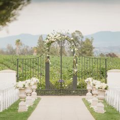 an outdoor ceremony setup with white flowers and greenery